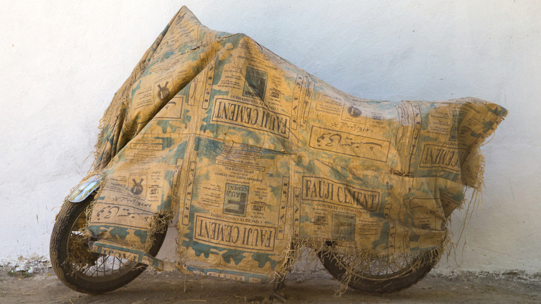 Motorcycle covered with dilapidated cement bags