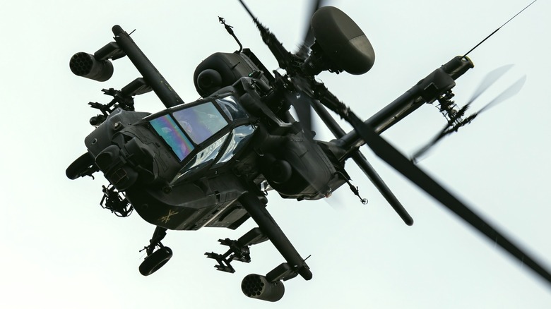 An AH-64 Apache in flight over grey skies