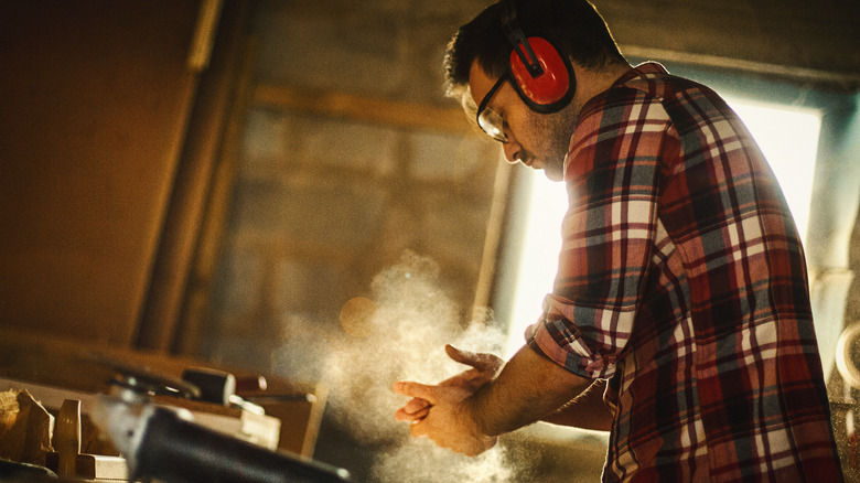 carpenter dusting off hands