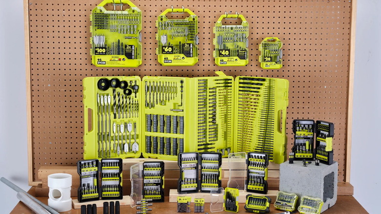 Several Ryobi drill bit sets displayed in front of a pegboard