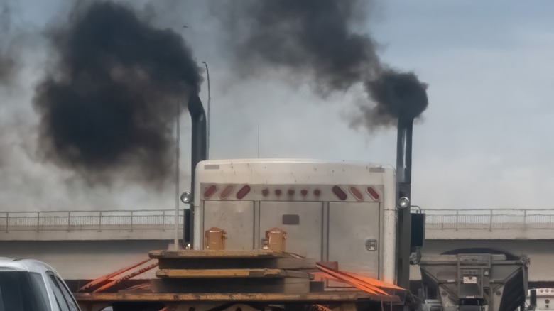 A diesel truck blowing thick smoke from its exhaust.